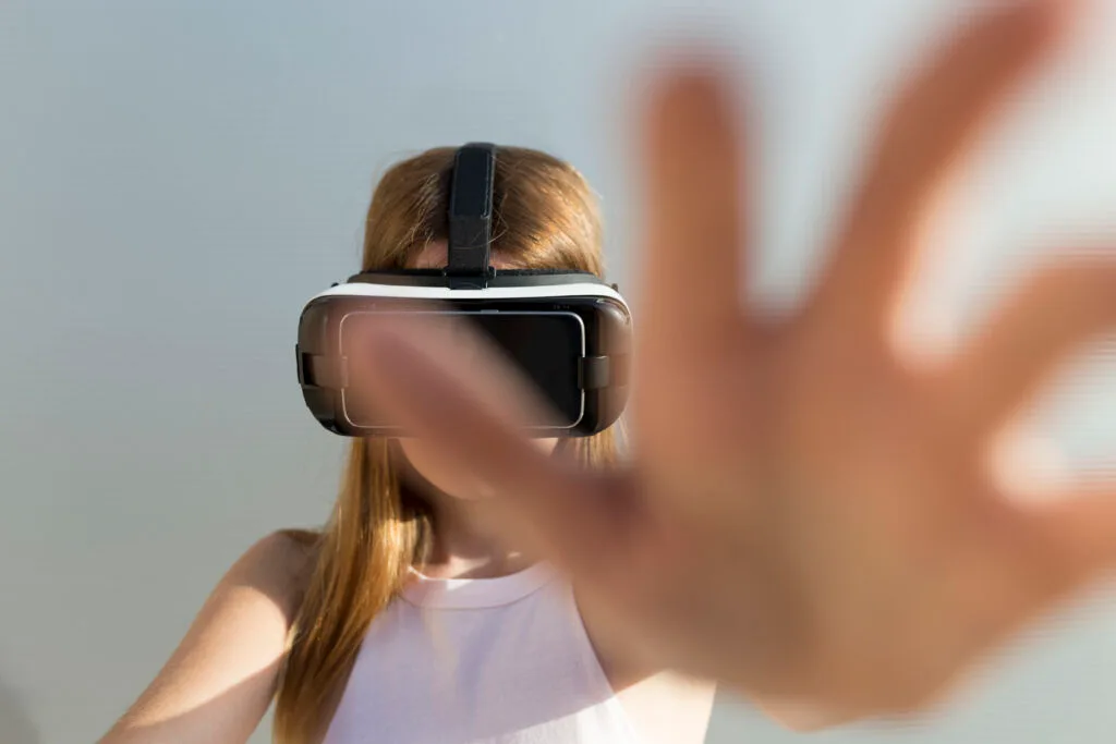young woman using vr googles reaching with her ha 2023 11 27 04 57 14 utc scaled